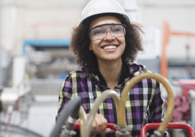 woman manufacturing work smiling wearing hardhat